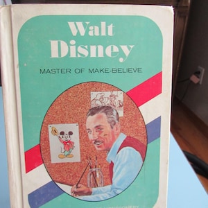 May include: Vintage book titled "Walt Disney Master of Make-Believe" by Elizabeth Rider Montgomery. The cover features a portrait of Walt Disney, illustrations of Mickey Mouse, and a teal, red, and blue color scheme. The book is part of the "Americans All" series.