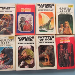 May include: A collection of vintage paperback books by John Norman, featuring titles like "Priest-Kings of Gor" and "Raiders of Gor." The covers display colorful illustrations of fantasy scenes and characters, with text in bold, white fonts.