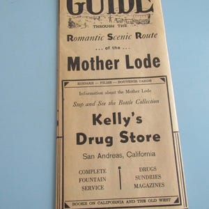 May include: A vintage brochure with the title "GUIDE" and the text "Romantic Scenic Route...of the...Mother Lode." The brochure also advertises Kelly's Drug Store in San Andreas, California, and lists services like drugs, sundries, and magazines.