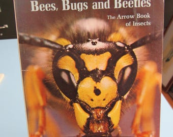 May include: A book cover featuring a close-up of a yellow and black wasp with the title "Bees, Bugs and Beetles: The Arrow Book of Insects" by Ronald Rood.