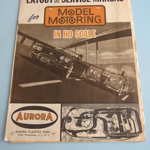 May include: A vintage 1961 Aurora Model Motoring layout and service manual for HO scale slot cars. The cover features black and white illustrations of two sports cars on a highway, the Aurora logo, and a diagram of a model race track layout.