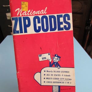 May include: A red book with the title "National ZIP CODES" in blue letters. The book features a cartoon illustration of a mail carrier holding a letter and a star-shaped design with the text "Nearly 50,000 LISTINGS, ALL 50 STATES - 9 Islands, MULTI-CODED CITY Listings, CROSS REFERENCED."
