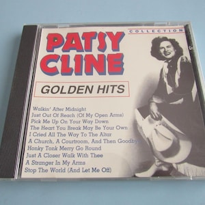 May include: A Patsy Cline "Golden Hits" CD album. The cover features the artist's name in red and blue, with a black and white image of Patsy Cline holding a hat. Song titles are listed below.