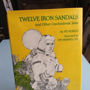 May include: A yellow book cover with the title "Twelve Iron Sandals" and "And Other Czechoslovak Tales" in green text. The book is illustrated with a black and white drawing of a person wearing a long dress and a crown, with a large moon in the background.