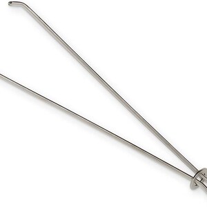 May include: A silver-toned metal kitchen tool featuring two long, thin arms that extend from a looped handle. The arms are constructed from a single piece of wire, bent to form a V-shape, with small, outward-curving hooks at the ends of each arm.