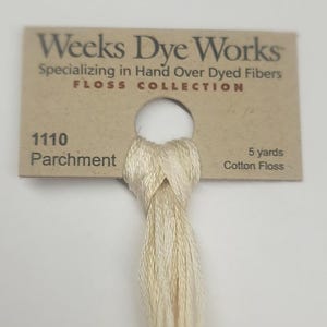 May include: A skein of Weeks Dye Works floss in the color Parchment, a light beige. The floss is 5 yards long and is made of cotton. The label reads "Weeks Dye Works" and "Specializing in Hand Over Dyed Fibers" and "FLOSS COLLECTION".