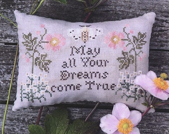 May include: A white pillow with cross-stitch embroidery featuring a butterfly and the text "May all your dreams come true". The pillow is surrounded by pink and white flowers and green leaves. The text "My Wish For You" is printed below the pillow.