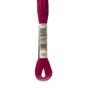 May include: A skein of deep magenta embroidery floss featuring a central white paper label. The label displays the number 150, a vertical barcode, and the text 2436027. The thread is twisted into a loop at the bottom and extends upward.