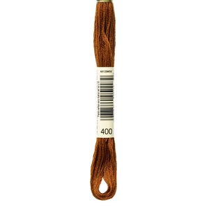 May include: A skein of brown embroidery floss. The floss is a rich, warm brown color. A white label with black text and a barcode is wrapped around the floss. The label reads "400" in a large font.