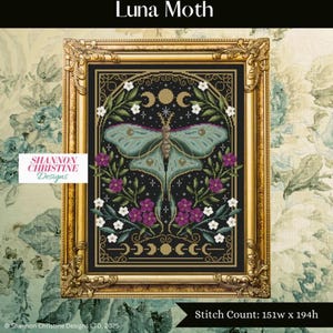 May include: A framed cross-stitch design featuring a Luna Moth with a teal and black color scheme. The moth is surrounded by purple and white flowers, with crescent moons and stars. The frame is gold with ornate detailing. The text "Luna Moth" is at the top.