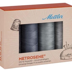 May include: A box of Mettler Metrosene thread spools in shades of gray. The box has a window showing three thread spools. The box also features illustrations of a thimble and a pin cushion. The text on the box reads "METROSENE® 100% Polyester - Universal thread."