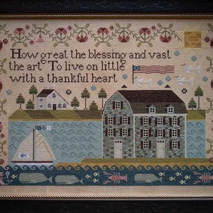 May include: Framed cross-stitch artwork featuring a coastal scene with a sailboat, houses, and the text "How great the blessing and vast the art To live on little with a thankful heart." The border includes floral and geometric patterns.