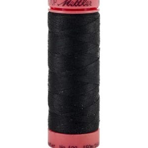 May include: A spool of black thread with a red top and bottom. The thread is tightly wound around the spool. The brand name "Mettler" is printed on the top of the spool. The thread is likely used for sewing or embroidery.