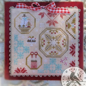May include: A cross-stitch sampler with a winter theme, featuring a snowman, snowflakes, and other holiday motifs. The design is framed in a red border and adorned with a red and white checkered ribbon. The sampler is approximately 10 inches square.