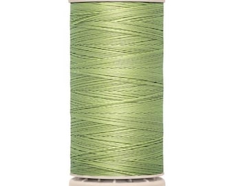 May include: A spool of Gütermann thread in a light green color. The spool has a white top and bottom with the brand name "Gütermann" printed on the top. The bottom of the spool reads "200 m - 220 yds/vgs".