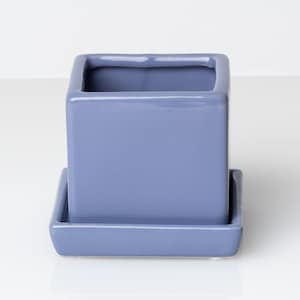 May include: A square ceramic planter with a matching saucer in a light blue color.
