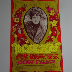 May include: A retro concert poster for Donovan, with a portrait of the musician in a striped jacket. The poster has a red and yellow colour scheme with floral accents and text that reads "ONE NIGHT ONLY FRI. SEPT. 22 COW PALACE."