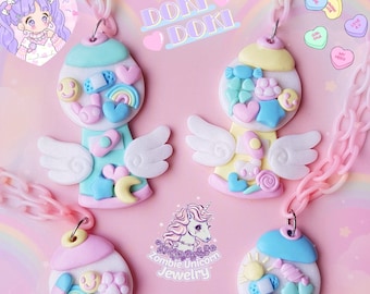 May include: Four pastel-colored gumball machines with wings, each filled with colorful candy hearts, stars, and other cute charms. The gumball machines are attached to a pink chain necklace. The text "Doki Doki" and "Fancy" are visible in the image.