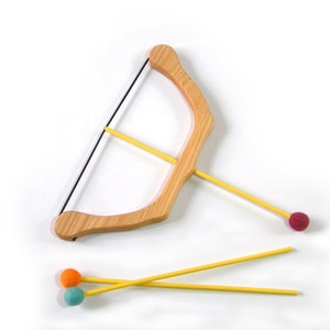 May include: A wooden toy bow and arrow set with yellow arrows and colourful felt tips. The bow is made of natural wood and has a string attached. The arrows are approximately 25 cm long.