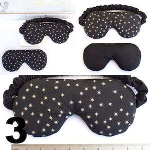 May include: Three black sleep masks with white stars. The top mask has a black elastic band. The middle mask is solid black. The bottom mask has a black elastic band and the number "3" in white.