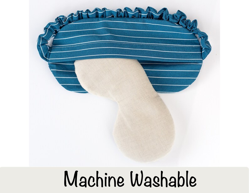 Puede incluir: Una m&aacute;scara para dormir de color turquesa con rayas blancas y borde con volantes. La m&aacute;scara tiene un inserto beige curvado y el texto "Machine Washable" en la parte inferior. Esta m&aacute;scara est&aacute; dise&ntilde;ada para la comodidad y el bloqueo de la luz.