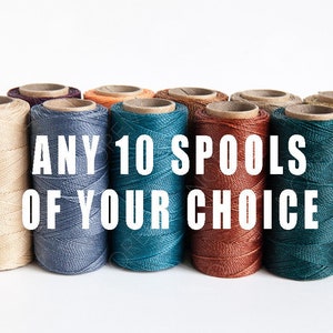 May include: Ten spools of thread in various colours, including beige, blue, teal, orange, brown, and gold. The text "ANY 10 SPOOLS OF YOUR CHOICE" is printed in white on a white background.