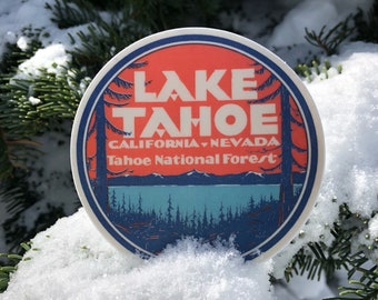 May include: A round sticker with a red, white, and blue design. It says "Lake Tahoe, California-Nevada, Tahoe National Forest" in white text.