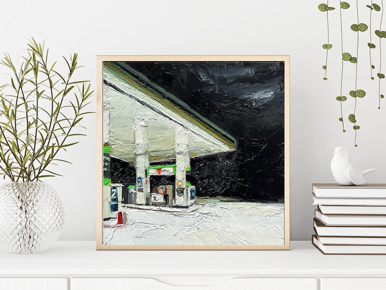 May include: A painting depicting a petrol station at night. The petrol station is painted in a realistic style with a focus on the texture of the paint. The petrol station is lit by a single light, which casts long shadows on the ground. The sky is dark and cloudy.