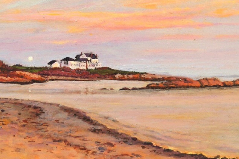 Gooseberry Beach in Newport Rhode Island at sunset with a moonrise. View of the white house on the point with reflections of sunset on the water.
