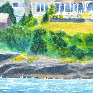 Waterfront of the Castle Hill Inn in Newport Rhode Island with rock lined coast set against a backdrop of green bushes along the lawn.