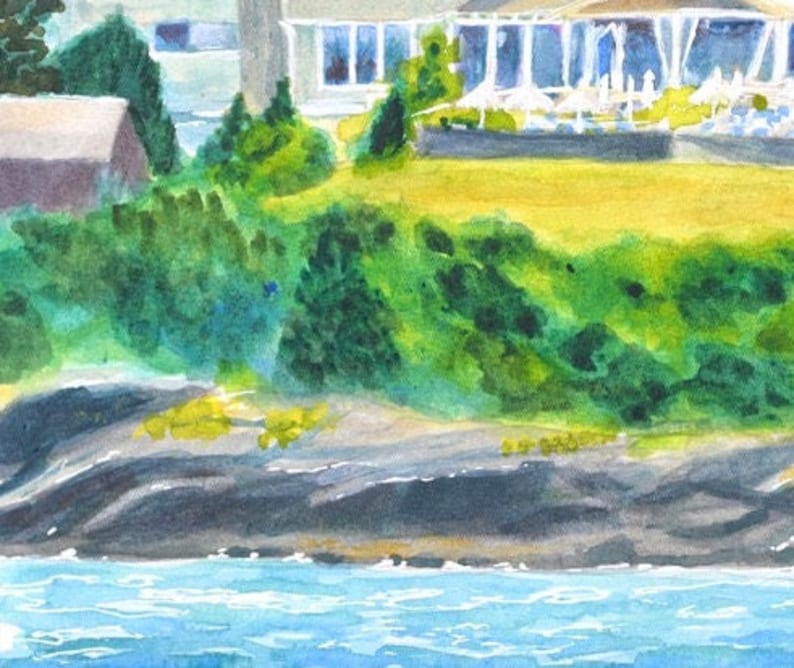 Waterfront of the Castle Hill Inn in Newport Rhode Island with rock lined coast set against a backdrop of green bushes along the lawn.