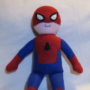 May include: A red and blue plush toy of Spiderman with a white face and black eyes. The toy has a spider symbol on the chest.