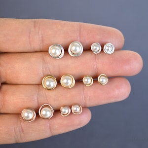 May include: Set of pearl earrings in different sizes. The earrings are made with gold and silver wire and feature a pearl in the center.