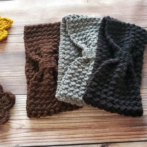 May include: Three crocheted headbands in brown, gray, and black. The headbands are made with a textured stitch and have a bow detail.