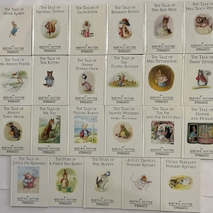 May include: A selection of Beatrix Potter's classic children's books, including "The Tale of Benjamin Bunny" and "The Tale of Jemima Puddle-Duck." The books have white covers with illustrations. The collection is arranged in rows, representing a timeless collection of children's stories.