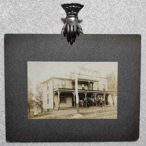 Large antique photo of many men hanging out at a tavern in town. Victorian era