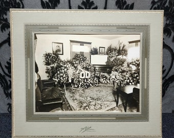 Post mortem photograph of an open casket. Orginal picture housed in a large art deco folder. 1900. In home funeral. Lapeer, Mi.