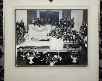 Post mortem photograph of a smiling old woman in his casket. Orginal picture housed in a folder. 1930s or 1940s.
