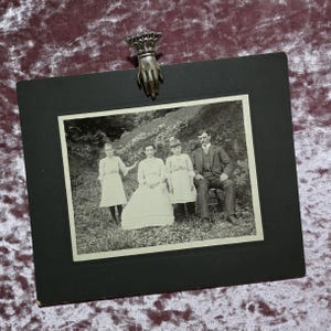 Ancienne carte de la fin de l'ère victorienne, grande carte pour armoire représentant une famille. Une mère, un père et deux jeunes filles fantomatiques.
