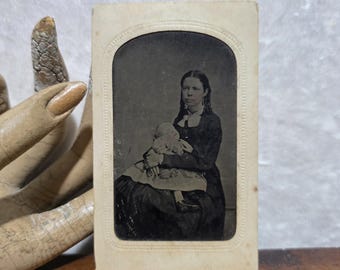 Antique, tintype photo of a post mortem toddler being held by mother. Victorian mourning era. Carte de viste.  Photograph. Photographer