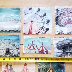 May include: A collection of six fabric squares featuring vintage circus and carnival imagery. The images include a Ferris wheel, carousel, and circus tent. A yellow tape measure shows a length of approximately 22 inches.