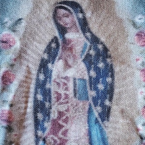 May include: A close-up of a printed fabric with a faded image of a woman in a blue robe. The fabric has a textured, woven appearance.