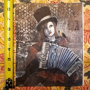 May include: A painting of a person wearing a top hat and a red coat playing a blue accordion. The person is surrounded by a gray and brown patterned background. A small bird is perched on the person's shoulder.