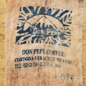 May include: A vintage coffee bag made of burlap with blue and white printed text and a logo. The text reads "Don Pepe Coffee, Cordoba-Veracruz-Mexico, Tel: (52)(2)734-2525-016-2094".