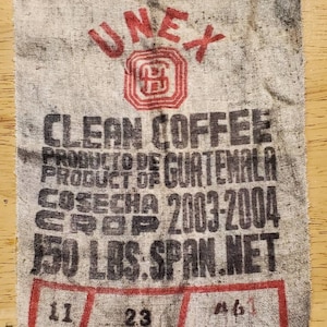 May include: A vintage burlap coffee bag with the text "UNEX CLEAN COFFEE PRODUCTO DE GUATEMALA PRODUCT OF COSECHA 2003-2004 CROP 150 LBS. SPAN.NET 11 23 461" printed on it.