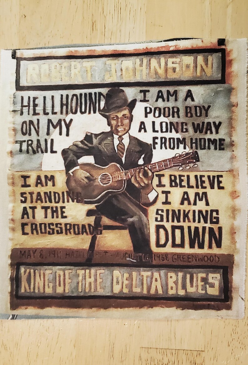 Pu&ograve; includere: Ritratto dipinto di Robert Johnson che suona la chitarra, con testi come "Hellhound on My Trail" e "King of the Delta Blues". L'opera presenta una figura seduta in abito e cappello, con testi di canzoni e date.
