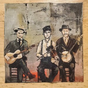 May include: A square fabric featuring a vintage-style illustration of three musicians. The musicians are depicted seated, playing a guitar, violin, and banjo. They are dressed in suits and hats, set against a textured, muted background.