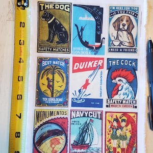 Op de afbeelding: Een stoffen vel met negen vintage-stijl lucifersdoosjes. De labels bevatten illustraties van een hond, een gondel, een beagle, een duiker, een haan, een palmboom, een zeilboot en twee vrouwen. Het vel meet ongeveer 23 cm in lengte.