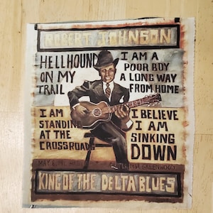 Pu&ograve; includere: Un'opera d'arte dipinta raffigurante Robert Johnson che suona la chitarra, con testo come "Hellhound on my trail" e "King of the Delta Blues". L'opera utilizza tonalit&agrave; marroni, nere e beige.