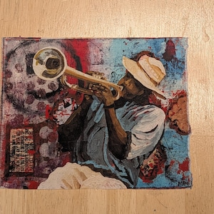 May include: A rectangular canvas painting featuring a musician in a light-colored hat playing a gold trumpet. The background is a textured mix of blue, red, and dark tones. A small rectangular block of text is visible in the lower left corner.